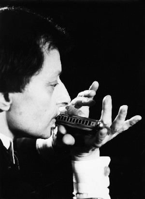 Claude Garden jouant de l'harmonica chromatique, photo en noir et blanc